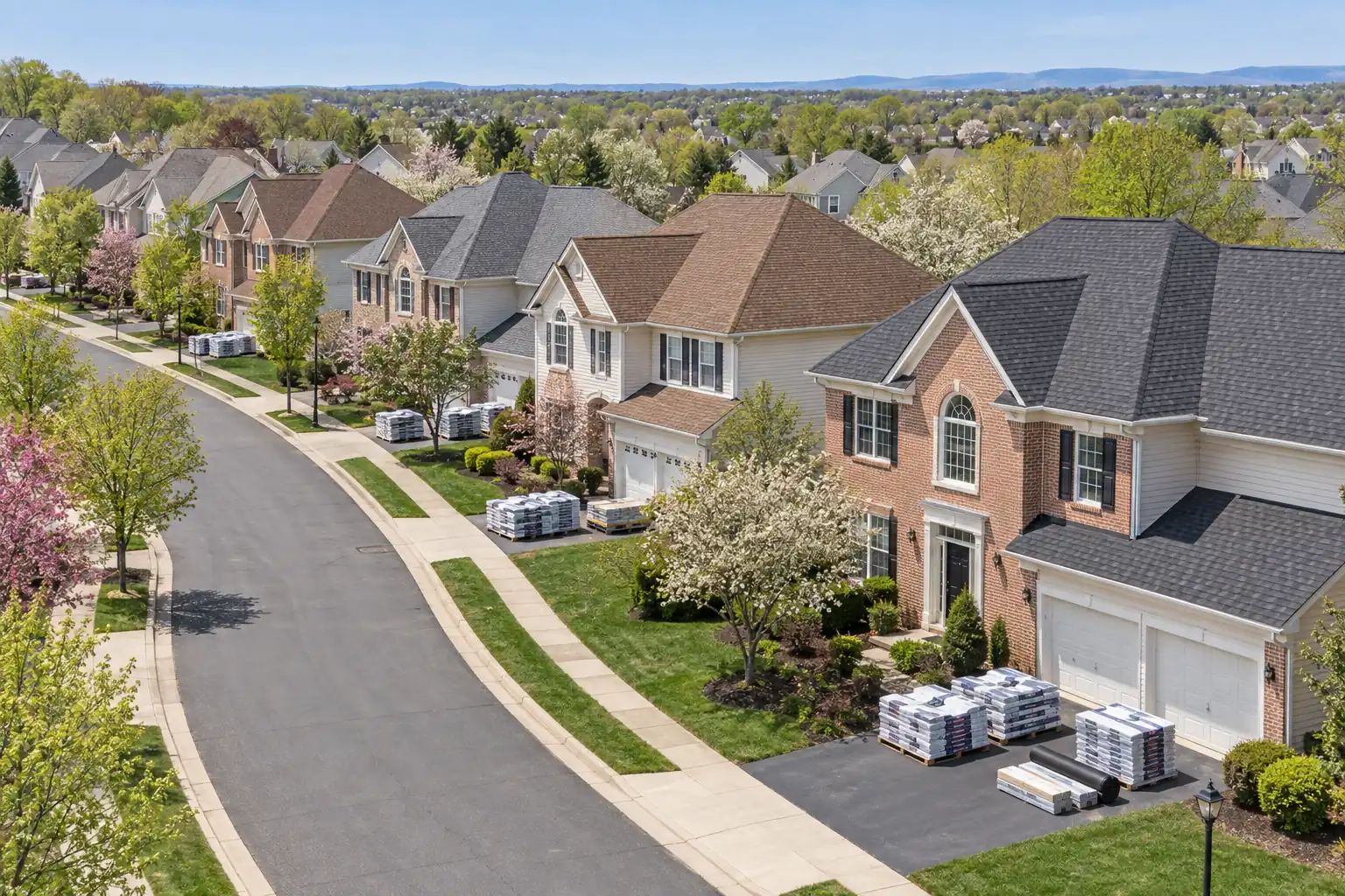 Ashburn Virginia subdivision street with coordinated roofs and roofing material deliveries at several homes