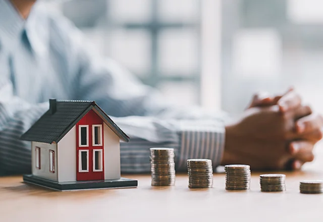 Model house and coin stacks illustrating roof financing options for Virginia homeowners